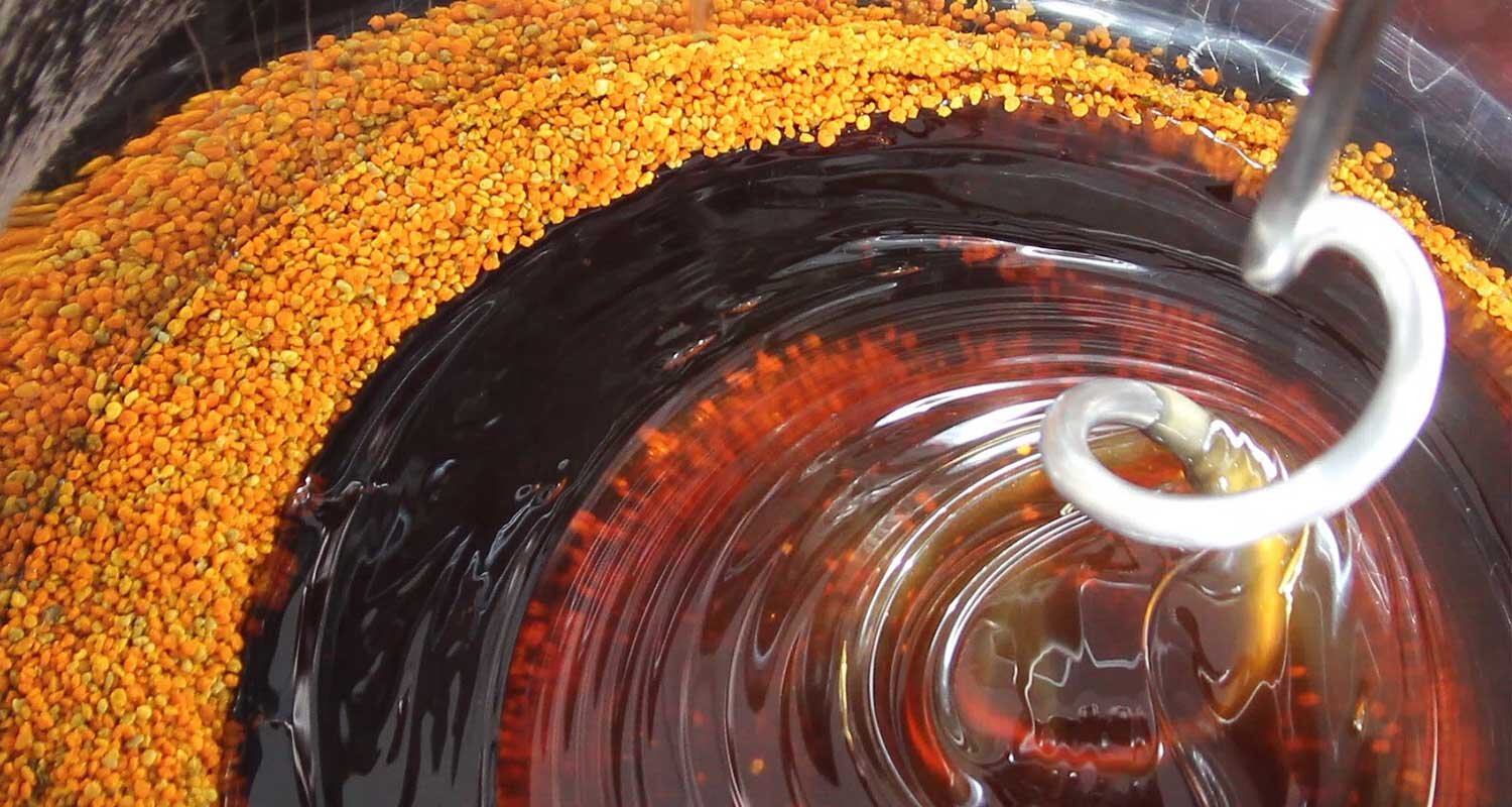 Blütenpollen wird in Honig eingerührt